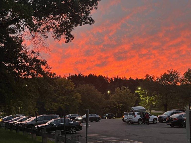 The sun sets over Hinman parking lot as a student’s family helps them unpack.